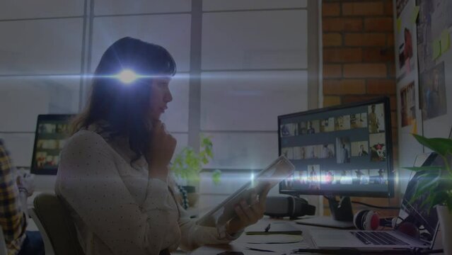 Animation of light trails over caucasian businesswoman using tablet