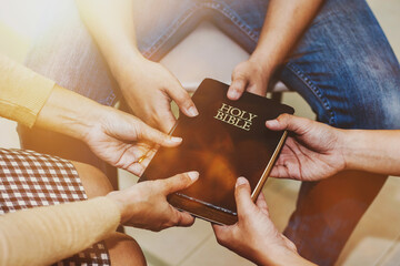 Three cristian friend hold bible and praying together with faith and trust or belief in God in small group fellowship . Power of hope or love, christian devotion background, bible study group  concept