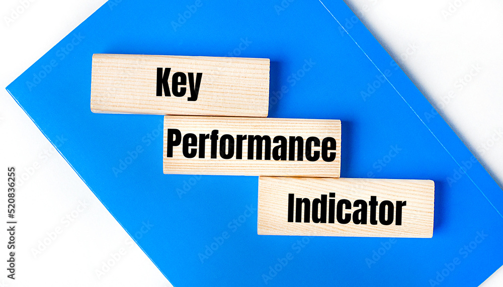 Poster there is a blue notebook on a light gray background. above are three wooden blocks with the words ke