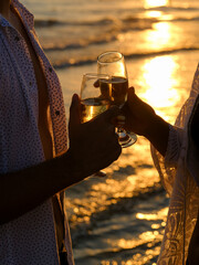 honeymoon couple drinking champagne on tropical beach