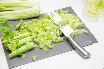 Fresh sliced celery. Cut celery sticks and leaves on wooden table. Bunch of fresh celery stalk with leaves. Preparing and cutting celery for drying. Dryer for fruits and vegetables.
