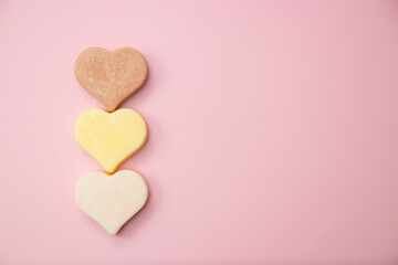 Heart shaped pink bar of soap on a light pink background. Top view, copy space. Heart shaped soaps. Importance of personal hygiene care. Copy space.