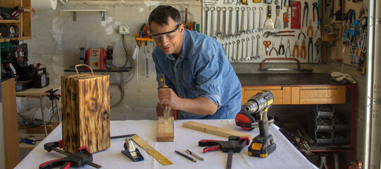 Image of a handyman who carves wood with a hammer and chisel. Do-it-yourself and bricolage works