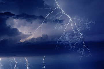 Obraz na płótnie Canvas Fork lightning striking down during summer storm