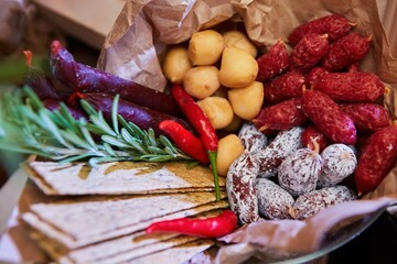 Assortment of a large number of different delicacies. Cheeses, sausages, canned food and bread, herbs and sauces.