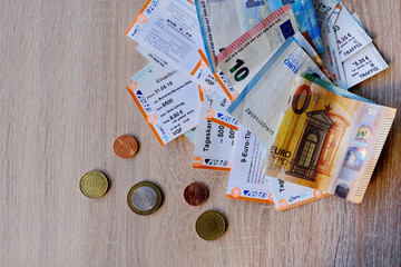 many tickets for day, for one trip, 9-euro travel subscription lies on table among euro coins and...