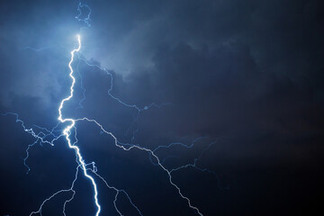 Fork lightning striking down during summer storm - Powered by Adobe