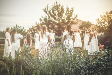 Women in white dresses dancing in nature. Ceremonial dance.