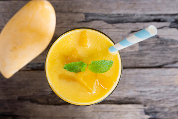 Fototapeta na wymiar mango smoothies orange colorful fruit juice beverage healthy high protein the taste yummy in glass on wood background from top view. 