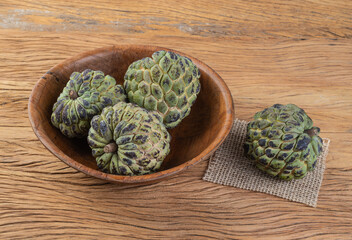 Sugar apples or custard apples in a bowl over wooden table