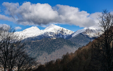 Peaks of a mountain range with cumulus clouds in Krasnaya Polyana