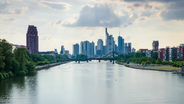 Frankfurt skyline time lapse, blue sky with clouds, office buildings and skyscraper in center with river and bridges in the foreground, Frankfurt am Main, Hessen, Germany