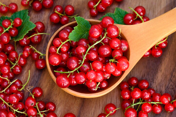 Red currant heap. Currant red with leaf on wooden background. Organic currants with soft focus. Currant top view.
