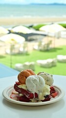 Ice cream waffles, Thai tea flavor, coconut milk and chocolate chips topped with fresh strawberries at a seaside café. Near sea. on the beach.