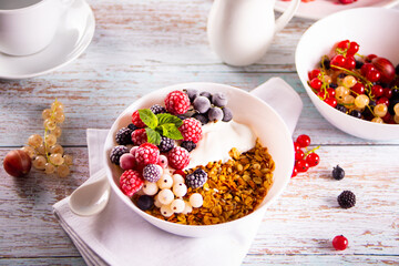 Granola, muesli cereals with yogurt or milk and fresh berries. Healthy breakfast concept.