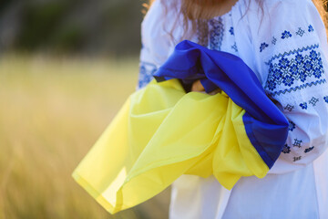 Hands of a teenage girl with a Ukrainian flag