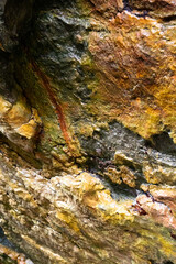 rocks near the beach with a great variety of veins of different colors and minerals, live and natural colored rocks
