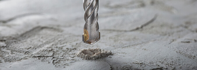 drill bit make holes in concrete wall with industrial drill. Building work industry.