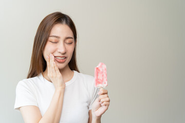 Face expression suffering from sensitive teeth, Asian young woman touching cheek