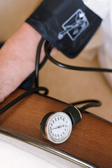 Tonometer for non-invasive measurement of blood pressure on the arm of an elderly woman