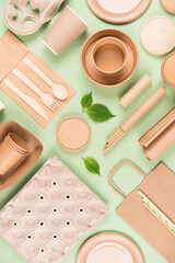 Vertical flat lay composition with eco tableware, paper utensils and wooden bamboo cutlery set over...