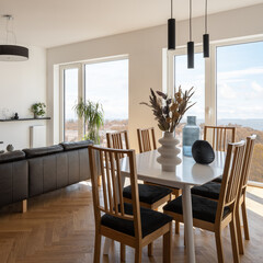 Decorated dining table in room with big windows
