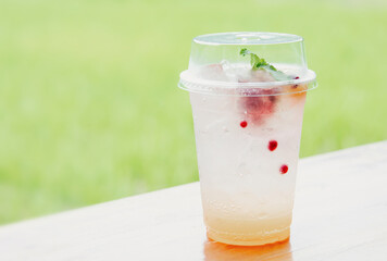 Italian juice soda in a plastic cup on table in cafe.