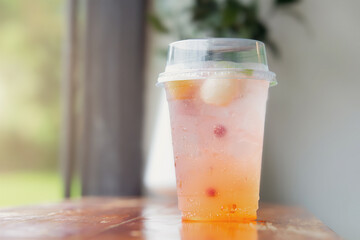 Italian juice soda in a plastic cup on table in cafe.