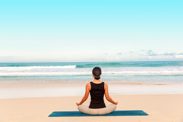 Fototapeta premium woman practicing yoga at seashore of tropic beach,Sports lady standing at the beach make yoga exercises