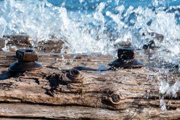 Waves crashing and spraying over a freshwater shipwreck remains with large bolts