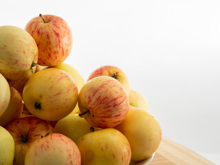 Fresh red apples on a wooden table with a white background.