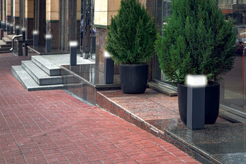 walkway made of stone tiles along building with thresholds and steps with entrances to shops lined...