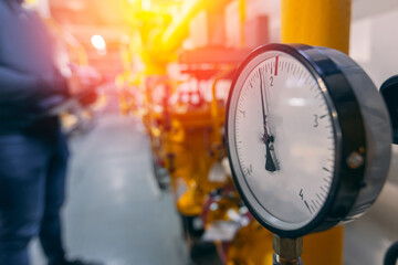Worker engineer check pressure meters on natural gas yellow pipeline red valves. Concept industry...