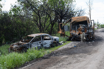 Fototapeta premium Burned and broken cars. War in Ukraine 2022. Russian missiles in Kharkiv Ukraine. Russian aggression, conflict. Russian attack on Ukraine. 