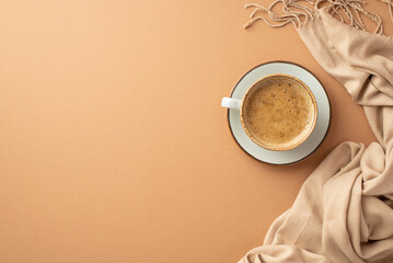Autumn aesthetic concept. Top view photo of cup of cocoa on saucer and plaid on isolated beige...