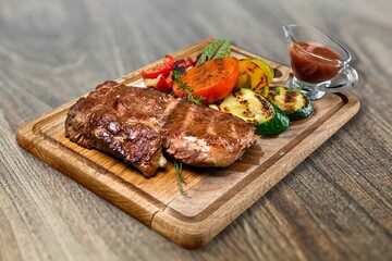 Slices of grilled steak pork on a wooden cutting board. Food concept