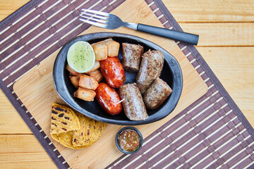 chirizos con morcilla y chicharrones, arepa, ají 