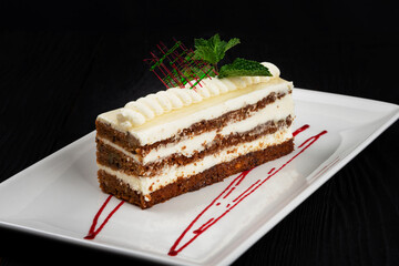 Chocolate cake decorated with mint leaves on black background