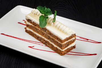 Chocolate cake decorated with mint leaves on black background