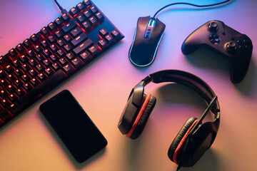 Gamer work space concept. gaming set up. top view of a gaming gear, keyboard, mouse, gamepad, joystick © adirestuuu