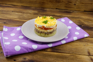 Traditional russian salad Mimosa on wooden table