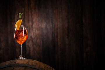 A glass of spritz aperol cocktail decorated with orange on cellar