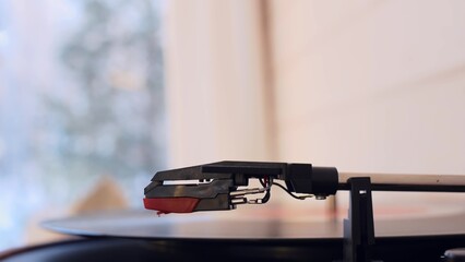 Close-up of a spinning vinyl record, the hand of a person who turns on the turntable and lowers the needle on the turntable to listen to music. Classical music from a turntable.