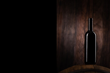 A Red wine bottle on wodden barrel with a wooden backgorund