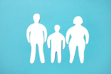 Silhouettes of a man, woman and overweight child on a blue background. - obrazy, fototapety, plakaty