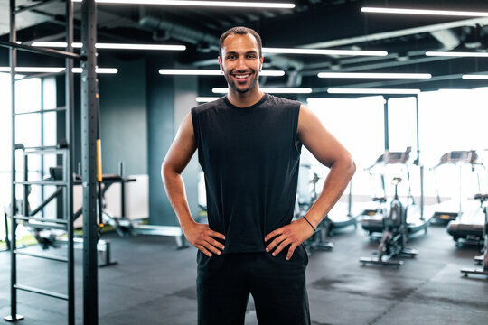 Portrait Of Handsome Black Personal Trainer Posing In Fitness Club Interior