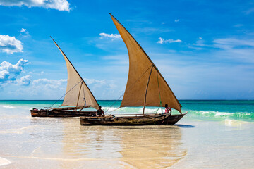 Sansibar, traditionelle Dhow-Holzboote an einem Strand im Indischen Ozean von Tansania in Afrika. - obrazy, fototapety, plakaty