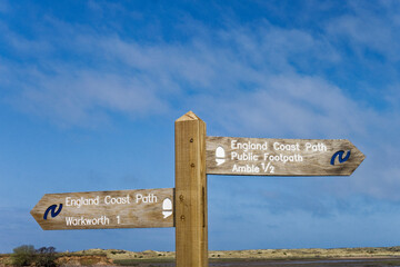 England coast path at the esturay of the river Coquet in Northumberland, Uk with signpost