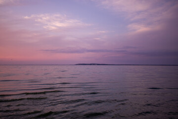 Pink sunset over the sea and island on the background
