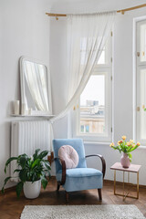 Blue textile armchair standing on wooden parquet floor